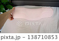 Point of view touching ergonomic orthopedic pillow on bed. Feeling soft memory foam texture, checking comfort and shape for cervical support, neck alignment and better sleep at home. 138710853