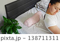 Woman lying on ergonomic orthopedic pillow on bed. Demonstrating cervical spine support, proper neck alignment and comfortable sleep for posture correction and pain relief at home. 138711311