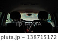 Car interior perspective from backseat viewing dashboard and front seats, showing vehicle cabin, journey experience, and travel activity with driver and passenger occasionally present. 138715172