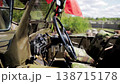 Interior view of vintage military vehicle, prominent black steering wheel, detailed dashboard instruments, camouflage pattern seats, red flag accessory, outdoor exhibition setting 138715178