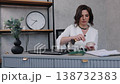 makeup touchup, professional woman, office lifestyle. Professional woman in white outfit using makeup brush at her desk, touching up her look during workday in modern office. 138732383