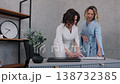 signing papers, career partners, office documents. Two professional women in formal clothing collaborate at modern office desk, with one signing documents as other supervises. 138732385