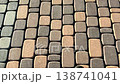 Walking slowly on a rectangular paving stone sidewalk. 138741041