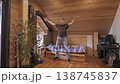 Man performing jumping jacks exercise indoors 138745837