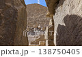 Dramatic upward view of Pyramid of Menkaure limestone blocks from base with scattered ruins at Giza, Egypt. Imposing ancient structure against blue sky. 138750405