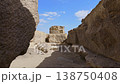 Pyramid of Khafre framed between large granite boulders with desert plateau and camels at Giza, Egypt. Unique perspective of ancient wonder under vivid blue sky. 138750408