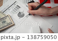 Bookkeeper places signature on internal Danish financial overview highlighting enhanced settlements alongside paid seal. 138759050