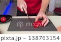Person Slices Red Peppers Neatly. Closeup Of Hands Slicing Colorful Peppers On Kitchen Counter 138763154