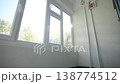 Multi-pane plastic window illuminates staircase near pipe 138774512