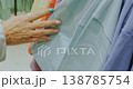 Woman Touching Clothes Hanging On Store Hangars 138785754