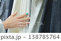Woman Touching Clothes Hanging On Store Hangars 138785764