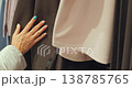 Shopper Running Her Hand Over Clothing Displayed On Rails 138785765