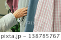 Shopper Running Her Hand Over Clothing Displayed On Rails 138785767