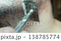 A close-up of a man using a traditional safety razor. 138785774
