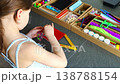 Little girl decorating handmade craft with colorful self adhesive rhinestones at table. Kids creativity fine motor skills development and learning through play concept. 138788154