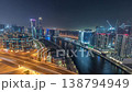 Glowing skyscrapers and highway bridge over Dubai canal night time-lapse 138794949