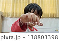 A curious young Thai boy tighten a screw with hexagonal wrench and looking on it carefully. 138803398