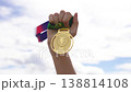 Victory With Patriotic Ribbon. Closeup Of Hand Holding Medal With Patriotic Ribbon Against Overcast 138814108