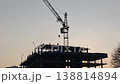 Silhouette of a construction site with a towering crane and workers 138814894