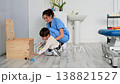 Child with disability performing motor skills exercises with physiotherapist using educational game 138821527