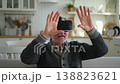 Excited mature senior man wearing using virtual reality metaverse VR glasses headset at home. Grandfather touching air during VR experience on virtual reality helmet. Simulation hi-tech videogame 138823621