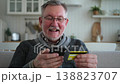 Senior man shopping online holding smartphone paying with credit card. Old grandfather buying on Internet enter credit card details. Online shopping delivery service Older generation modern tech usage 138823707