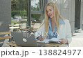 Focused Businesswoman Writing Notes While Having Online Video Call At Cafe 138824977