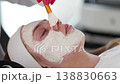 Aesthetician carefully applies an even layer of clay mask to the client's face, providing deep cleansing and balancing for the skin 138830663