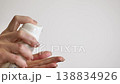 Woman pressing cosmetic pump to apply cream Woman pressing cosmetic pump to apply cream 138834926