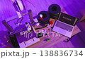 A 3D printer is actively creating the word HOME with white filament while a laptop displays the same word on its screen, surrounded by spools of filament and tools 138836734