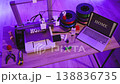 A 3D printer is actively creating the word HOME with white filament, surrounded by spools of filament, tools, and a laptop displaying the same word 138836735