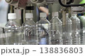 Close up of empty plastic bottles moving along automated conveyor in factory. Packaging production line with modern machinery used in beverage or liquid industry manufacturing. 138836803