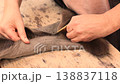 Close up of a furrier holding a sharp furrier knife and large replaceable blade while cutting a sable pelt. Craftsman carefully separates the hide during preparation for layout  138837118