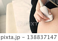 ultrasound screening close up of pregnant womans belly with medical scanner 138837147