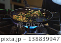 Cooking vegetables on a stovetop with high heat flame 138839947