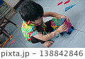 The development of fine motor skills in a preschool Asian boy in a colorful shirt. 138842846