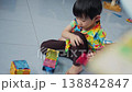 The development of fine motor skills in a preschool Asian boy in a colorful shirt. 138842847