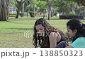 Teen Girls Talking and Laughing Sitting on Grass 138850323