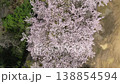 Aerial footage: A drone captures a bird's-eye view of a cherry tree in full bloom, slowly rotating as it ascends. 138854594