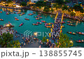 Aerial hyperlapse of adult men and women on small boats with lanterns near a crowded bridge over the 138855745