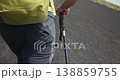 Male hiker is walking on dark rocky volcanic terrain near Etna Volcano, Sicily 138859755