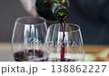 An elegant dinner scene of pouring red wine into a glass. 138862227
