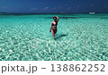 Woman walking in shallow turquoise water in Maldives 138862252