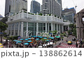 A tilt-up shot from worshippers at the Erawan Shrine in Bangkok to the Grand Hyatt Hotel on Ratchadamri Road, highlighting the contrast between spiritual devotion and luxury urban living. 138862614