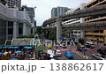 The bustling Rama and Ratchadamri Rd junction in Bangkok features BTS tracks overhead, with the iconic Erawan Shrine seen in the bottom left, blending urban energy with Thai spirituality. 138862617