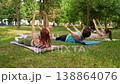 Group of women doing abs exercises on grass mats outdoors together during summer fitness class. Abs exercises, mats, group, fitness, outdoors, women. 138864076