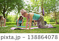 Group of women doing abs exercises on grass mats outdoors together during summer fitness class. Abs exercises, mats, group, fitness, outdoors, women. 138864078