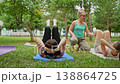 Group of women doing abs exercises on grass mats outdoors together during summer fitness class. Abs exercises, mats, group, fitness, outdoors, women. 138864725