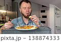 Person Displays Grimace After Tasting Fiery Food While Sipping Water And Evaluating Flavor 138874333