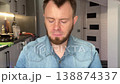 Caucasian Man Sampling Homemade Potato Stew At Kitchen Counter, Thoughtful Expressions, Fork And Torn Bread 138874337